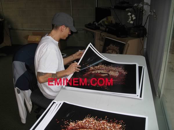 Eminem sat down to personally sign 1000 album cover posters.